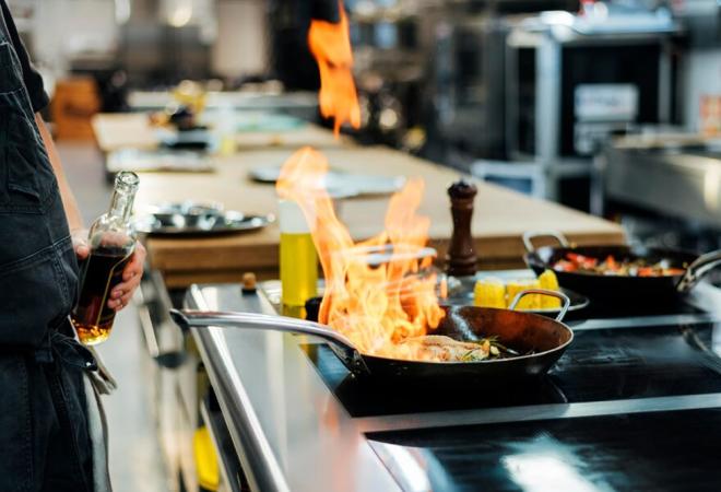 Chef cucina con fiamme vivaci, creando un'atmosfera di passione e creatività.