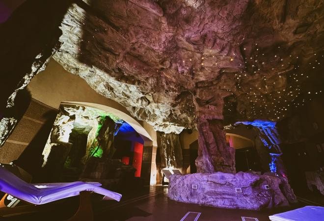 Ambiente sotterraneo, luci colorate e sedie relax creano un'atmosfera magica e suggestiva.
