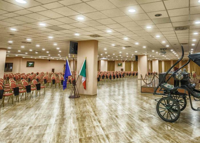 Elegant conference hall with antique carriage and flags. Solemn and historical atmosphere.
